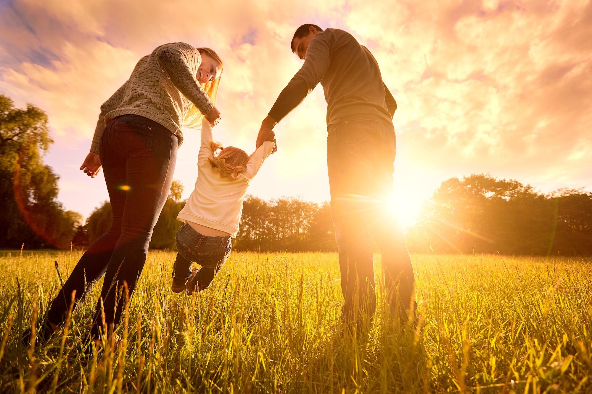 Two parents holding there child up.