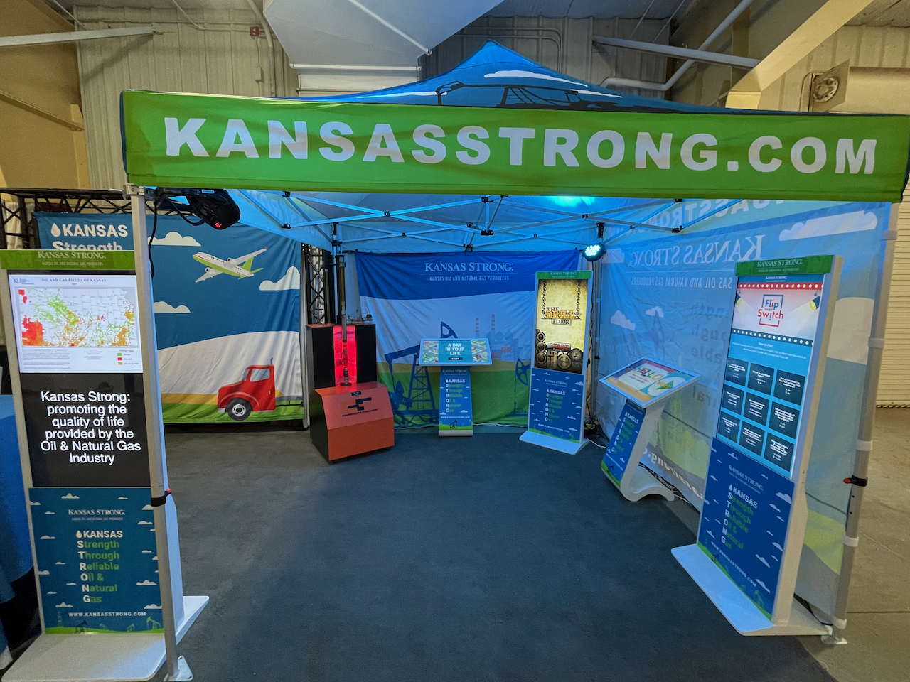 A tent with kiosks and banners displaying Kansas Strong's educational material.